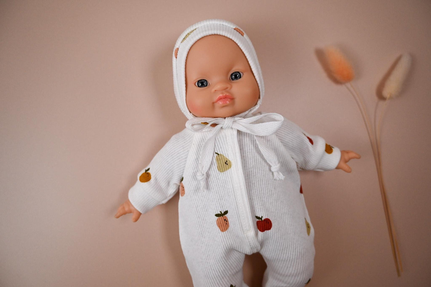 This cosy footed romper is made from soft, ribbed cotton jersey and sprinkled with colourful fruit illustrations – apples and pears on a creamy white background. It comes with a matching bonnet, making it perfect for naps, cuddles, or market day adventures.
Handmade from 100% cotton ribbed jersey
Fits Minikane 28cm dolls
Soft, simple, and stitched with care — perfect for dreamy doll moments.