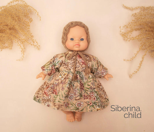 Inspired by blooming meadows and gentle days, this dress and bonnet set brings timeless charm to your doll's wardrobe.

The long-sleeved dress is made from soft cotton with an intricate wildflower print in warm earthy tones — perfect for woodland walks and vintage-style play. Paired with a hand-crocheted bonnet, the outfit adds a sweet, nostalgic touch to every doll adventure.



Handmade : dress from 100% Cotton, Bonnet from Wool/Acrilic yarn

&nbsp;Fits Minikane 28cm dolls