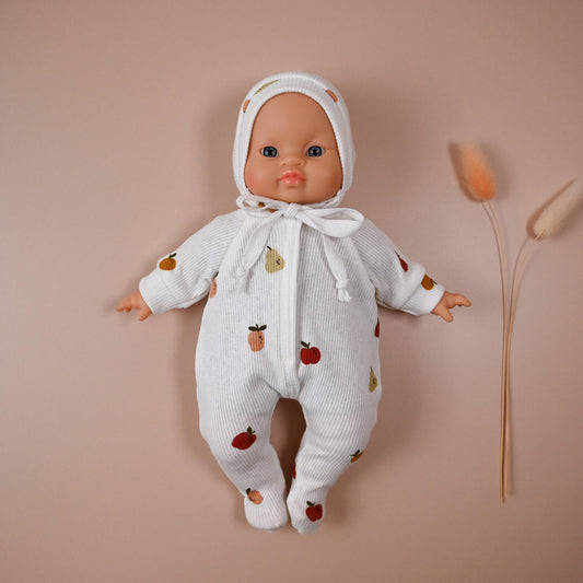 This cosy footed romper is made from soft, ribbed cotton jersey and sprinkled with colourful fruit illustrations – apples and pears&nbsp; on a creamy white background. It comes with a matching bonnet, making it perfect for naps, cuddles, or market day adventures.

Handmade from 100% cotton ribbed jersey

Fits Minikane 28cm dolls

Soft, simple, and stitched with care — perfect for dreamy doll moments.