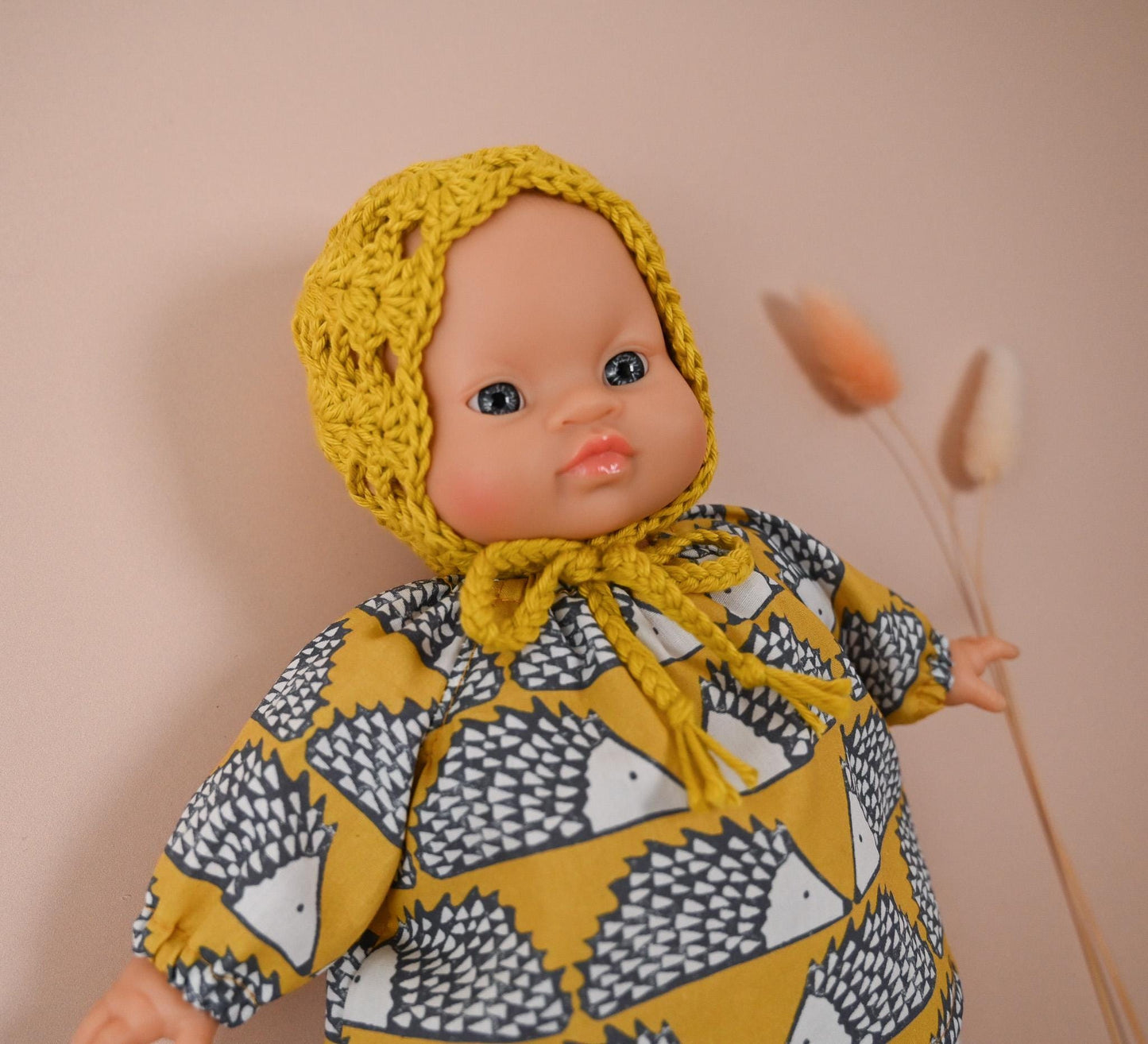 A cheerful outfit full of character and comfort! 🦔
This set includes a soft, long-sleeved cotton top featuring a charming hedgehog print in mustard tones — bold, fun, and perfect for woodland-inspired play. It’s paired with delicate white eyelet knit tights and a hand-crocheted mustard bonnet to keep your doll extra cosy and cute.