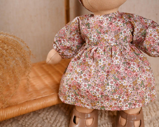 This sweet floral set is full of charm and perfect for everyday adventures. The puff-sleeve dress features a soft pink and wildflower print, made from lightweight cotton — breathable, soft, and just the right amount of vintage.

It’s paired with a matching oversized bow headband to complete the look, making it ideal for tea parties, garden strolls, or simply looking adorable on the shelf.
