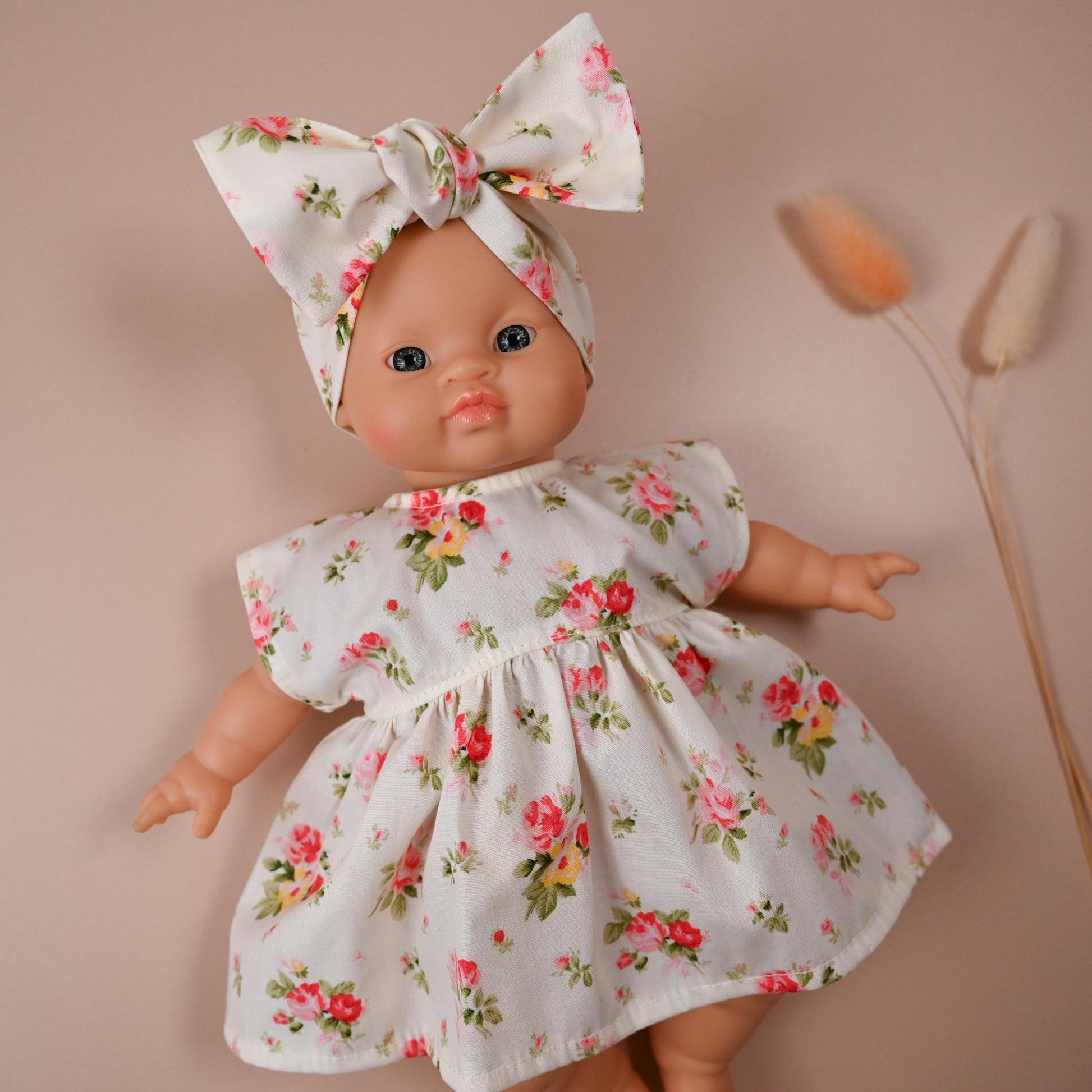 This sweet and summery set is full of timeless charm. The dress features a soft ivory background scattered with blooming vintage-style roses in shades of pink, red, and yellow — perfect for sunny strolls and tea party play.

The oversized matching bow headband adds a playful finish, completing a look that’s both classic and cheerful.