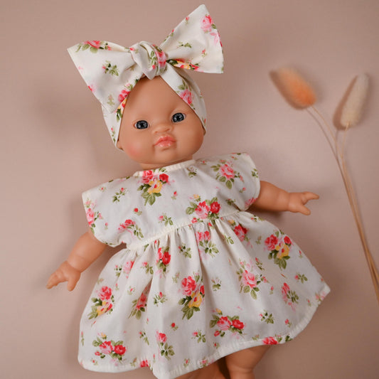 This sweet and summery set is full of timeless charm. The dress features a soft ivory background scattered with blooming vintage-style roses in shades of pink, red, and yellow — perfect for sunny strolls and tea party play.

The oversized matching bow headband adds a playful finish, completing a look that’s both classic and cheerful.